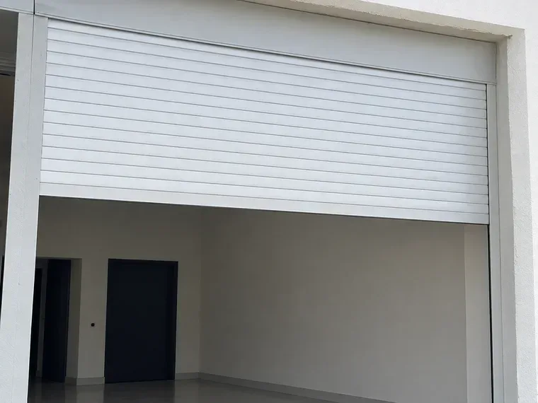Konya'da bir dükkân girişine takılmış motorlu otomatik çelik kepenk, yarı açık durumda