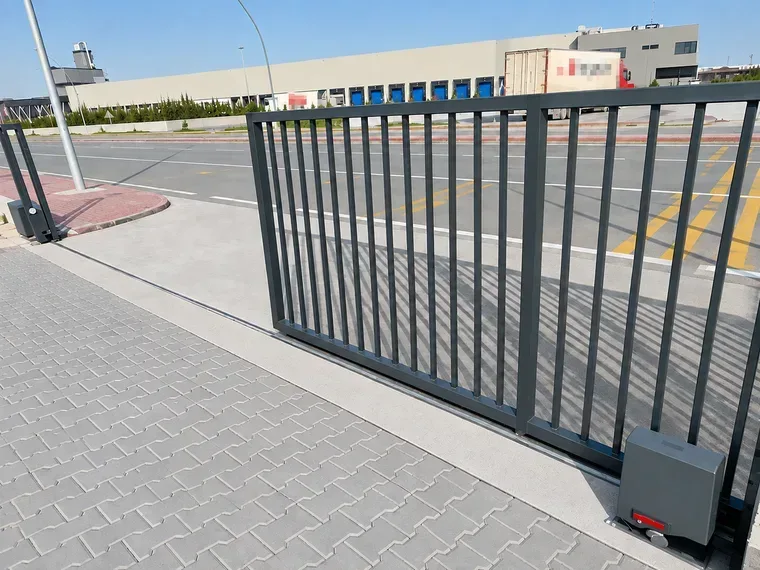 Konya'da bir sanayi tesisinin araç girişine kurulmuş motorlu kayar bahçe kapısı ve ray üstündeki kapı motoru